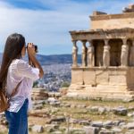 A female tourist takes pictures of the Erechtheion Temple at the Acropolis of Athens, Greece, during her summer vacations