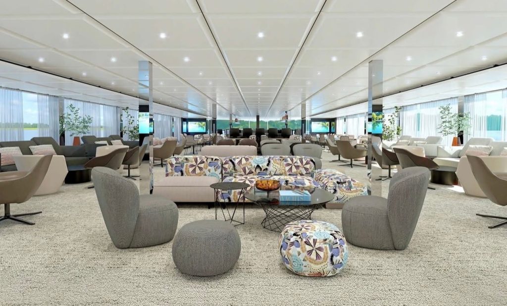 Spacious modern lounge with grey seating, patterned couches, and glass coffee tables? (informative image)