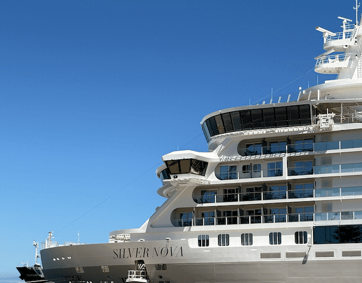 Silver Nova cruise ship's white hull and balcony decks against a clear blue sky.