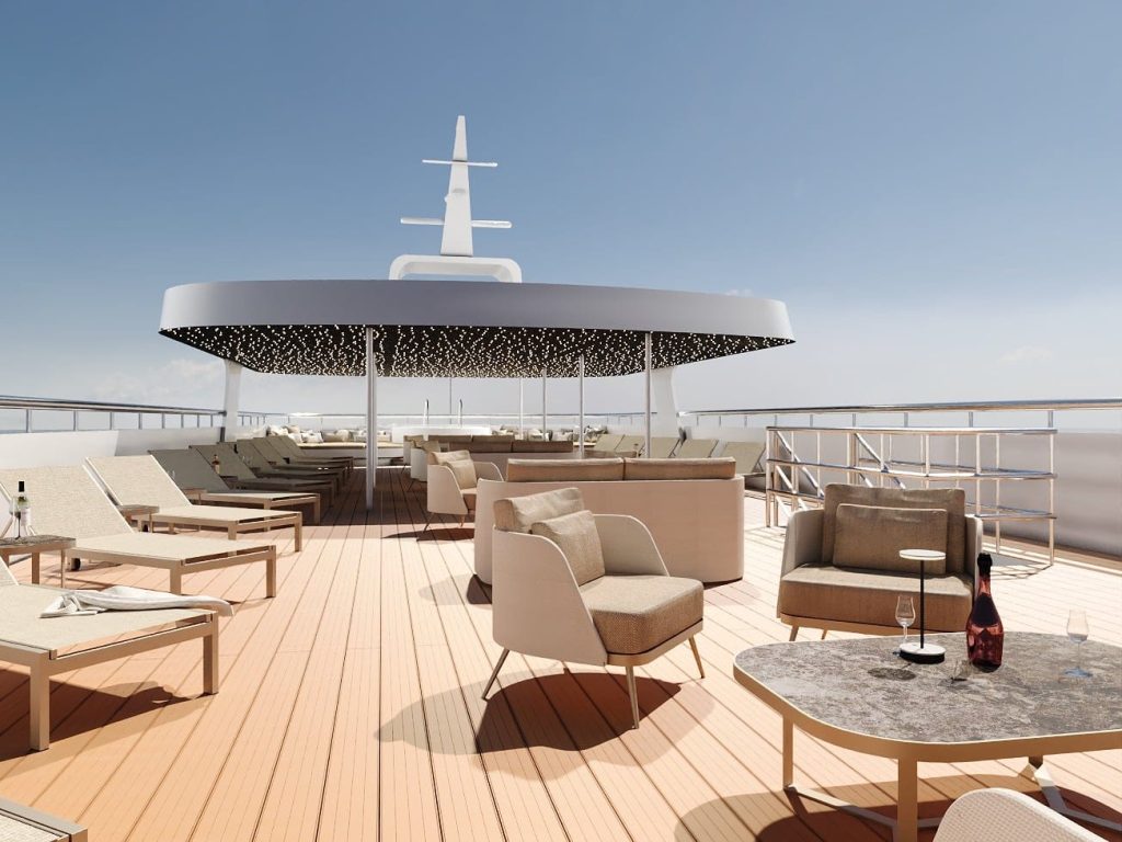 Ship sun deck with lounge chairs, armchairs, shaded canopy and a bottle of champagne on a table.
