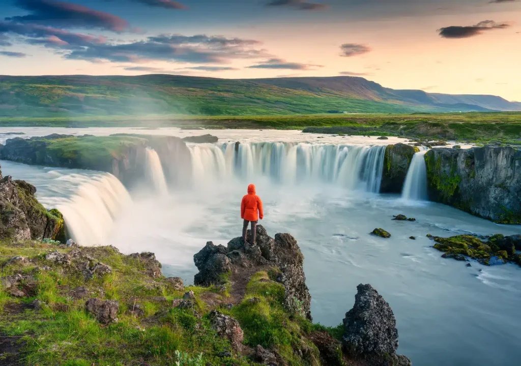 A Person Standing By the Cliff of the Godafoss Waterfall in North Iceland 1