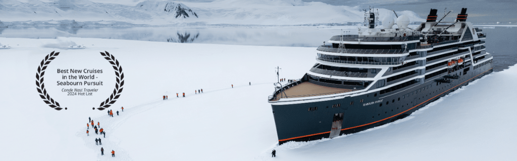 Expedition ship beside a snowy shoreline, with a laurel badge naming it a Condé Nast Traveler 2024 Hot List cruise.