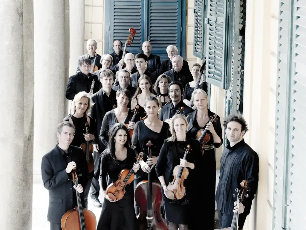 A large ensemble of musicians in black,