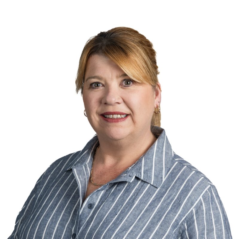 Close-up portrait of a woman with short light brown hair, wearing a blue and white striped shirt, smiling at the camera.