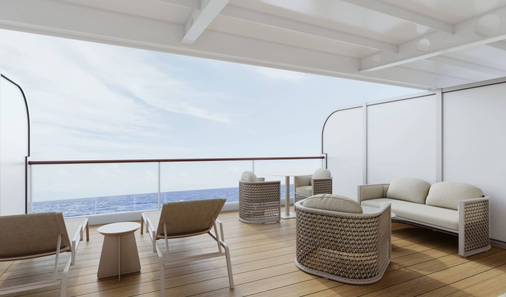 Elegant open-air lounge on a balcony with white furniture and wicker chairs overlooking the ocean horizon.