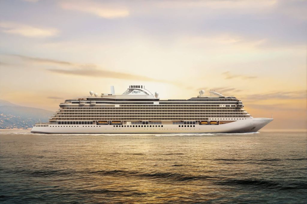 Large cruise ship sailing on calm water during sunset with soft orange sky and distant mountains in the background