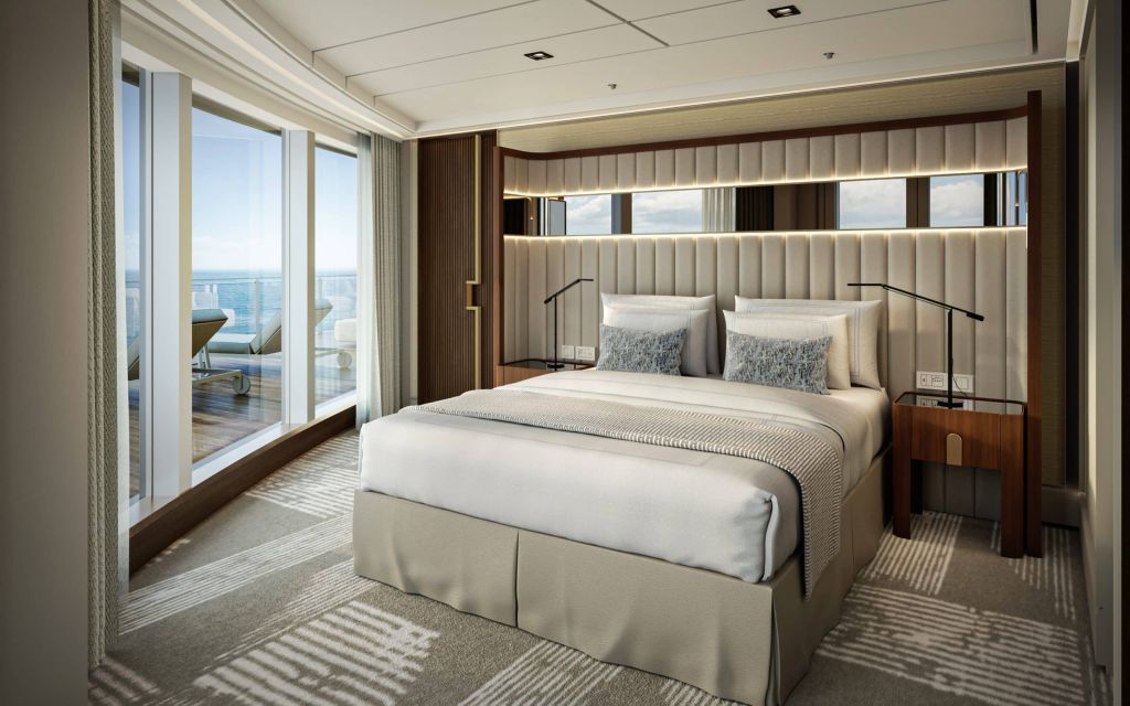 Luxurious hotel bedroom with a king bed, upholstered headboard, and a balcony overlooking the ocean.