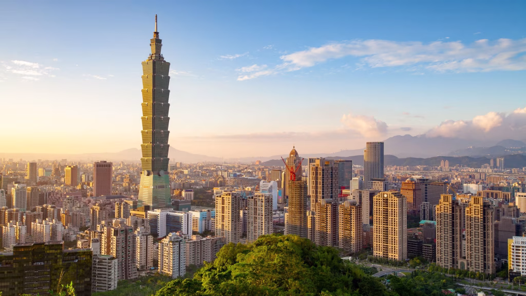 Taipei skyline at sunset with Taipei 101 towering above city blocks.