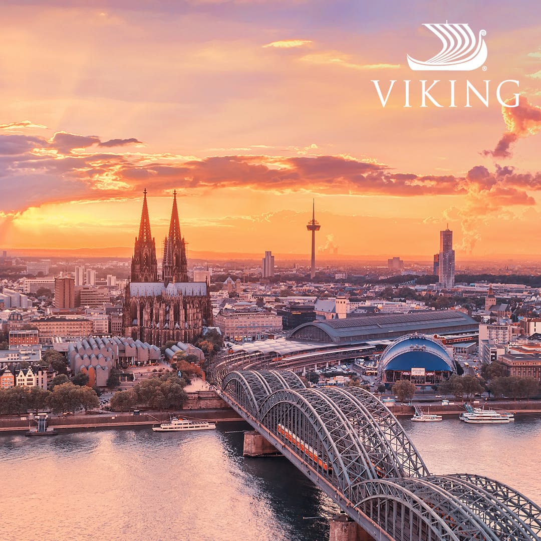 Sunset over Cologne with the Rhine, the Hohenzollern Bridge, and the Cologne Cathedral, Viking branding in the sky above.