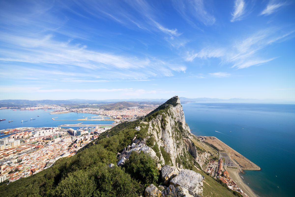 Gibraltar Rock view from above, on the left Gibraltar city and bay, La Linea town in Spain at the far end, Mediterranean Sea on the right.